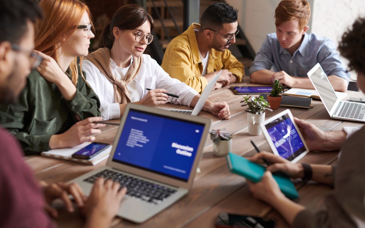 Team collaborating around laptops in an open office